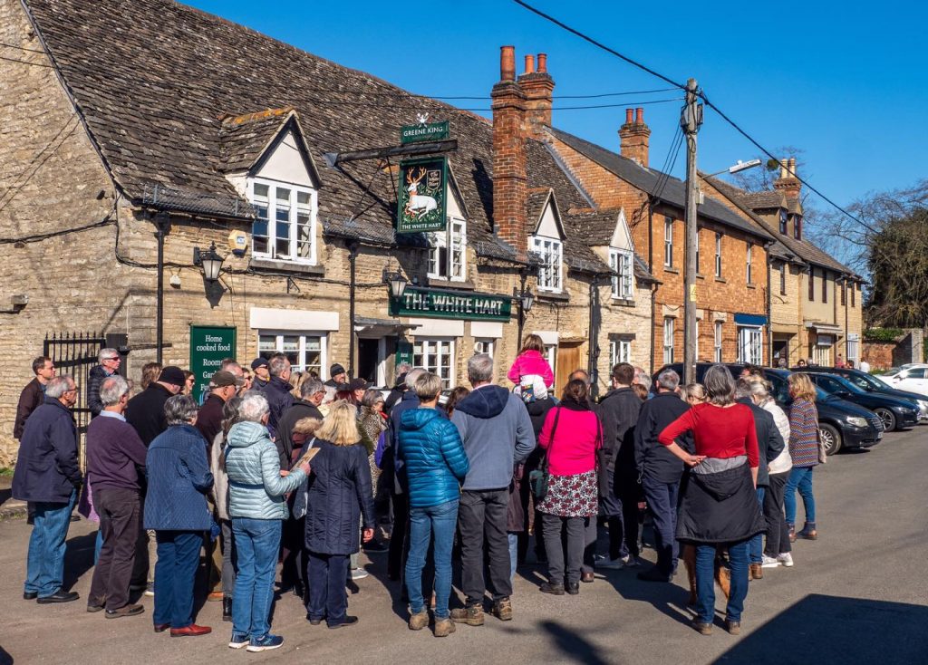 Photo of a group of people on a guided tour of Eynsham, standing outside the White Hart on Newland Street