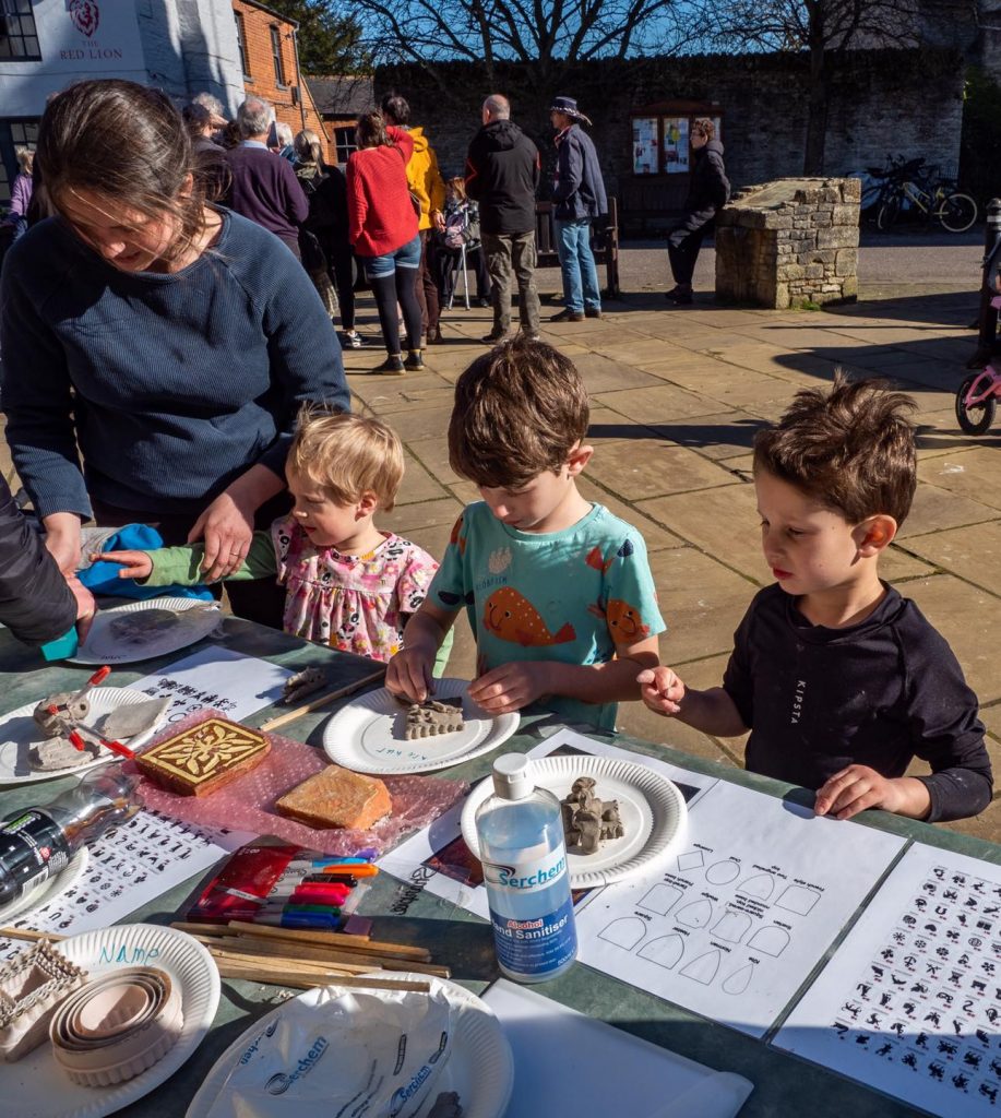 A photo of children participating in object identification activities in the Square during Eynsham Heritage Day in March 2022