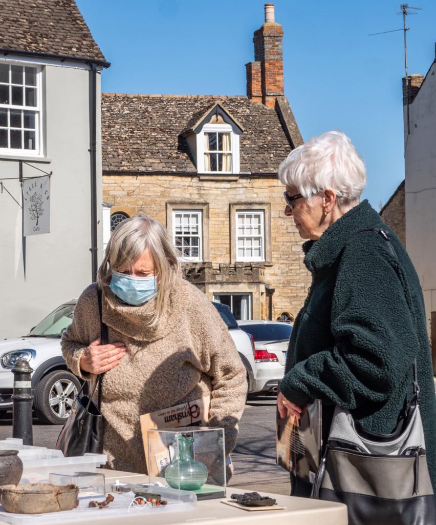 A photo of two women looking at ancient artefacts in the Square during Eynsham Heritage Day in March 2022
