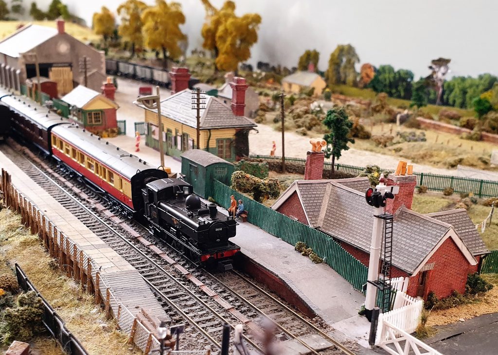 Model of Eynsham Station in the 1950s, created by David Thomas. Closer view of a passenger train at the station, with fields and trees at the back of the photo.
