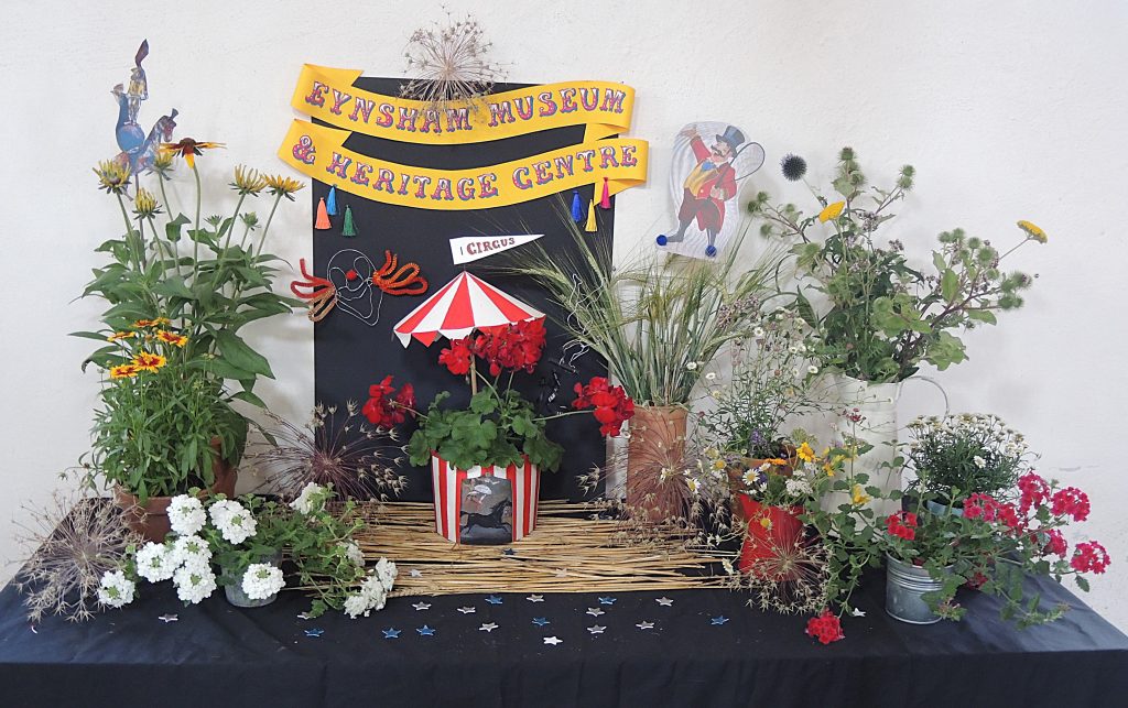 The museum's contribution to Eynsham Flower Festival, July 2025. The theme for the festival was Circus, and the collection of flowers in various containers is complemented by circus-themed adornments.