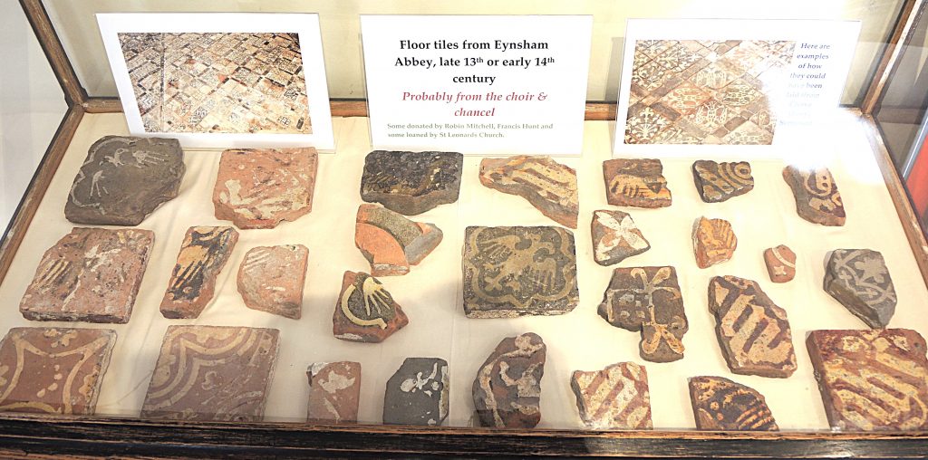 A display case with floor tiles and remnants of floor tiles from Eynsham Abbey