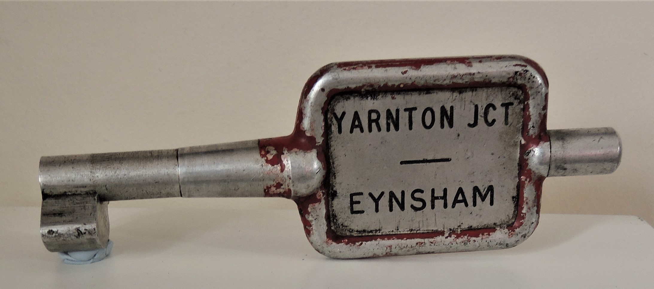 A single railway track key token. It looks a little like a key and is inscribed with the words Yarnton JCT and Eynsham.